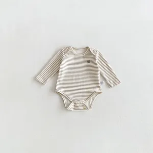 Close-up detail of infant long sleeve striped baby romper with cute bear embroidery texture.