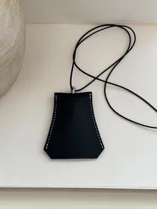 Vue rapprochée détaillée du collier pendentif géométrique en cuir noir avec de jolies coutures.