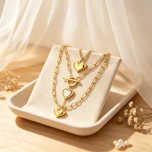 Primer plano de un conjunto de collares dorados de varias capas con colgantes de corazón.