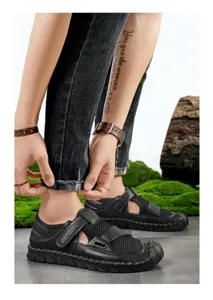 Close-up of black breathable mesh sandals with hand-stitched detailing on male model.