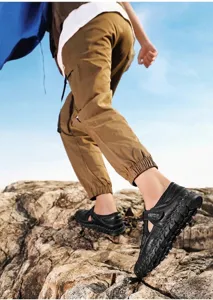 Close-up of men's black breathable beach sandals with handmade stitching in outdoor setting
