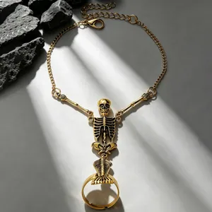 Detailed close-up of a golden gothic skeleton finger bracelet with artistic shadows.