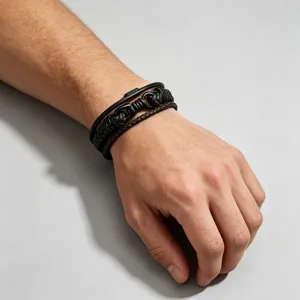 Gedetailleerde close-up van de meerlaagse lederen armband om de pols met fijne textuur.