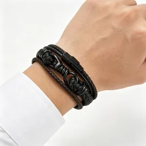 Detailweergave van de meerlaagse lederen armband met gevlochten design en sluiting.