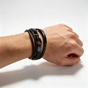 Gedetailleerde opname van de meerlaagse zwarte lederen armband met metalen plaat streetwear.
