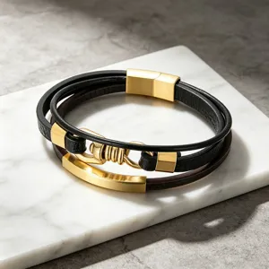 Detailopname van de elegante meerlaagse lederen armband met gouden metalen sluiting.