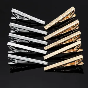 Set di eleganti fermacravatte in metallo dorato e argentato con varie texture e strass.