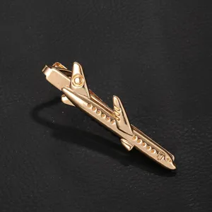 Détail de pince à cravate métal avion doré, accessoire homme élégant pour chemise chic.