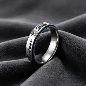 Gedetailleerde close-up van een titanium stalen paarring met gegraveerde love-tekst en kristal.