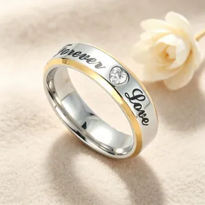 Detailweergave van de titanium stalen koppelring met gegraveerde tekst en hartje zirkonia.