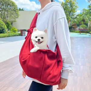 Vista detallada al aire libre de un bolso bandolera rojo para mascotas con perrito.