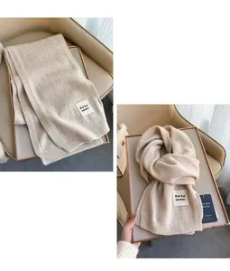 Primo piano dettagliato di una morbida sciarpa in lana beige con trama lavorata a maglia.