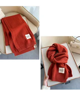 Dettaglio sciarpa di lana lavorata a maglia, accessorio invernale color ruggine.