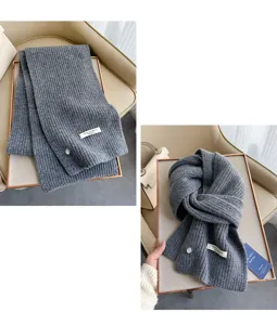 Grauer Merinowoll Strickschal Detailansicht mit weicher Textur und Markenetikett.