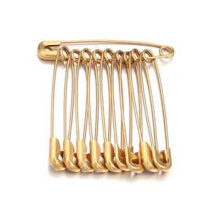 Primo piano dettagliato di spille da balia dorate in acciaio inossidabile per accessori.