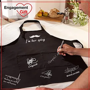 Gros plan d'un tablier de couple en polyester noir avec des signatures manuscrites en cuisine
