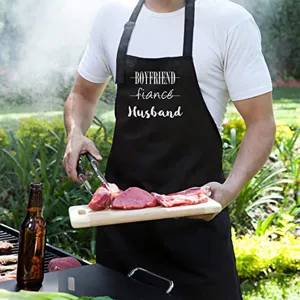 Tablier halter en polyester noir avec design de texte amusant pour cuisine et barbecue.