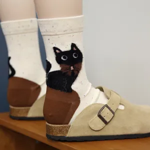 Primo piano del tacco con gatto nero soffice 3D su calzini di cotone accoglienti.