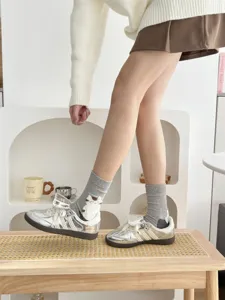 Vista dettagliata di calzini da donna in cotone con gatto carino e scarpe argento.