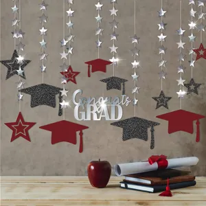 Detailaufnahme der Abschlussfeier Hängendekoration mit glitzernden Sternen und Mützen.