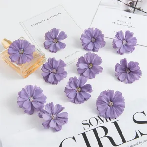 Detailopname van paarse kunstmatige madeliefje bloemhoofdjes met glitters voor DIY handwerk decor.