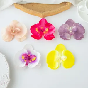 Close-up detail of artificial phalaenopsis flower heads in multiple vibrant colors for decoration.