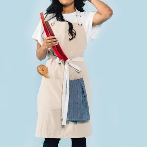 Detail view of cotton linen kitchen apron with front pockets and useful hanging loop design.
