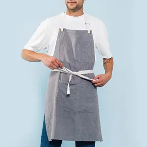 Grey linen apron detail showing durable cotton straps, deep front pockets and breathable fabric.