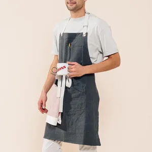 Detail view of dark gray linen canvas work apron with multiple pockets and adjustable straps.