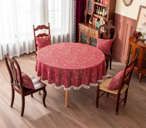 Vue détaillée d'une nappe ronde jacquard rouge festive avec de superbes franges blanches.