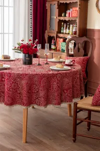 Nappe de table ronde rouge festive avec motif jacquard doré et bordure en dentelle.