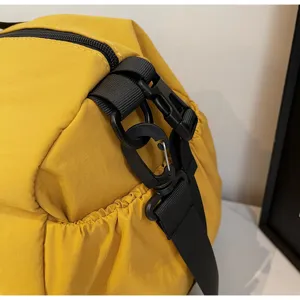 Detail van gele sporttas met duurzame zwarte gespen en hardware voor de schouderbanden.