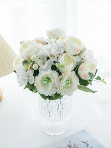 Close-up of elegant artificial flower bouquet in clear glass vase for decor detail view.