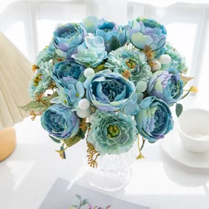 Artificial blue peony flower bouquet in glass vase for home decor, living room tabletop.