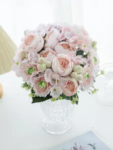 Artificial pink flower bouquet in clear glass vase, detailed close-up home decor.