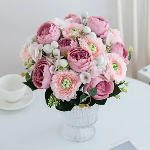 Artificial flower bouquet detail, pink peony and ranunculus arrangement in clear glass vase.