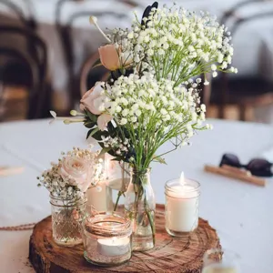 Gedetailleerd uitzicht op bruiloft middelpunt bloemen van kunstmatige gipskruid met glazen vaas.