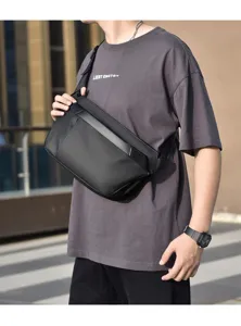 Detailansicht der schwarzen funktionalen Brusttasche am Model mit robustem Stoff und Gurt.