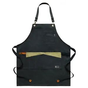 Tablier de travail noir en toile réglable avec poches contrastées pour cuisine salon.