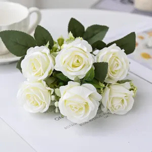 Detailed close-up view of elegant white artificial rose bouquet with green leaves for decor.