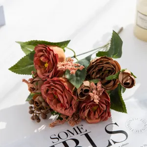 Primo piano di un bouquet di peonie artificiali vintage con bacche su tavolo.