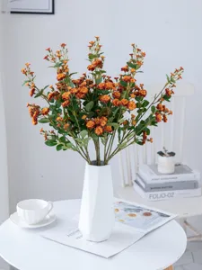 Artificial small rose flower bouquet detail, warm orange floral decor for home staging.
