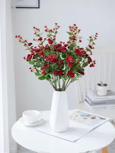 Artificial small rose flowers in white vase for home decor and photography props.