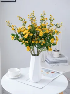 Artificial yellow mini rose flowers bouquet in white vase for home decoration and props.