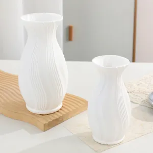 Moderne minimalistische weiße Plastikvase mit Rillen, elegante Tischdeko Detailansicht.