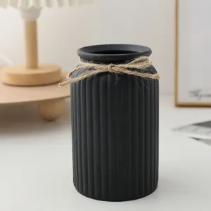 Jarrón de plástico negro minimalista con rayas verticales y lazo de yute para el hogar.