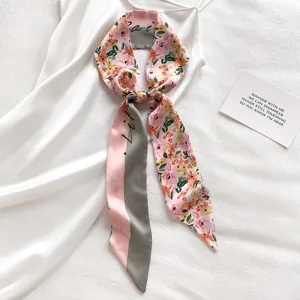 Detail van zijden sjaal met bloemenprint, elegant lang lint voor tas of haar.