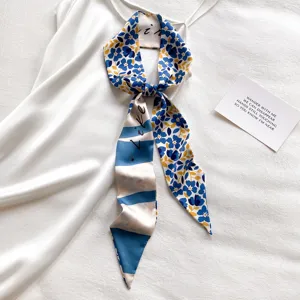 Detail van dunne sjaal, blauw bloemenpatroon en gestreepte achterkant met elegante platte ligging.