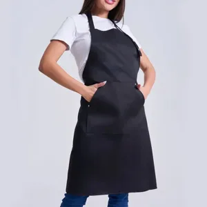 Detailed view of a black kitchen apron with pockets, professional workwear for chefs.
