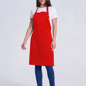 Red work apron detail view, featuring durable fabric, convenient pockets and stylish halter design.